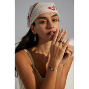 Gold wrap ring with blue stone and pearl accents, ideal for jewelry storage, jewelry websites, gem jewelry collections, and elegant, modern fashion accessories.