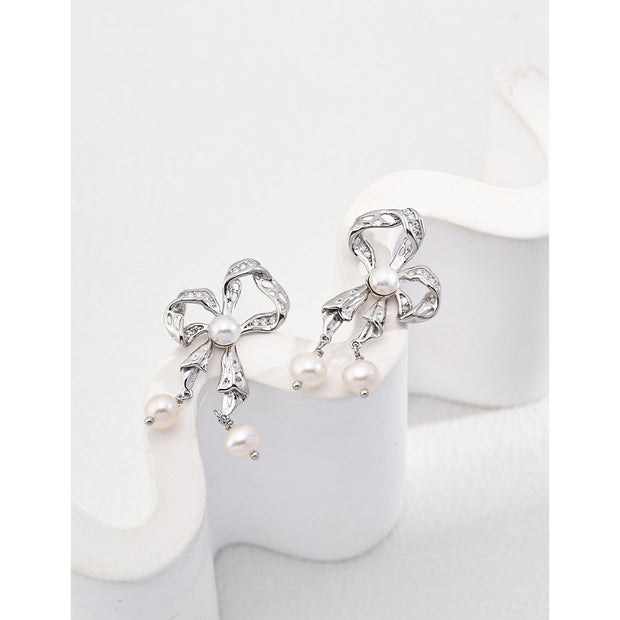 Gold and silver pearl bow earrings for jewelry storage and jewelry case enthusiasts. Perfect for vintage jewelry lovers, jewelry designers, and elegant styling.