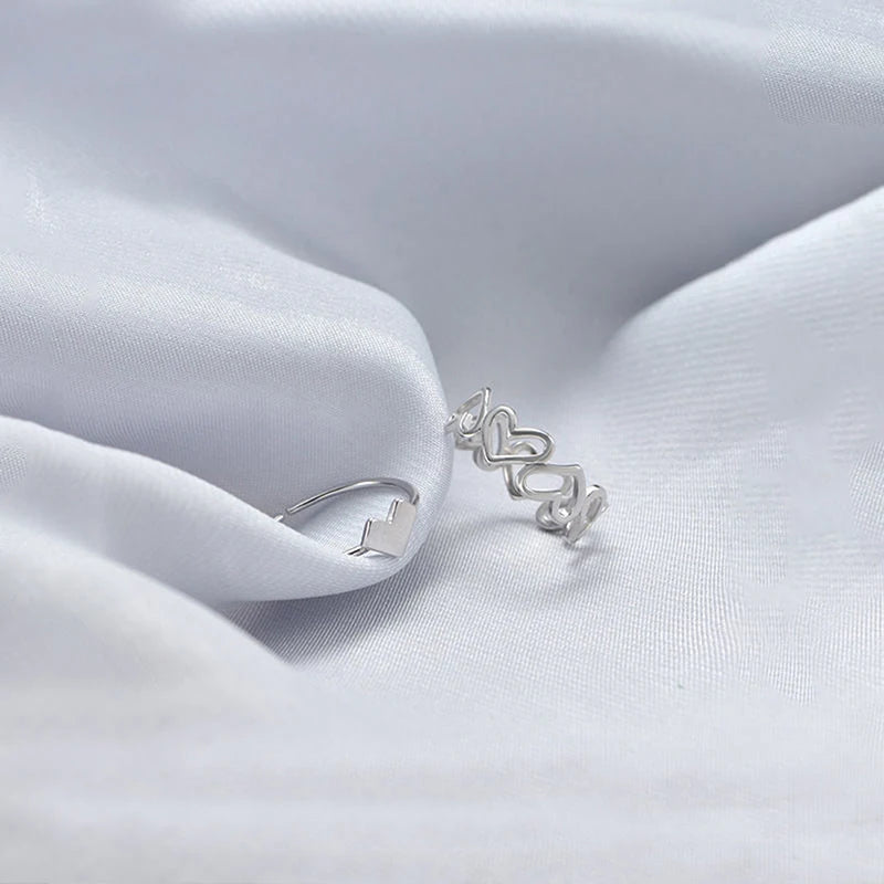 Elegant silver alphabet rings with gemstone accents displayed on hands, perfect for personalized jewelry options, showcasing jewelry designers' craftsmanship.