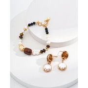 Elegant pearl and gemstone bracelet designed by leading jewelry designers, ideal for jewelry websites and jewelry storage. Featuring a mix of tiger's eye, onyx, and pearls, this vintage-inspired gem jewelry is perfect for mature women hairstyles, earrings piercing, and earrings rings. A must-have for jewelry of the sea lovers and those seeking jewelry with turquoise or engraving. Store in a jewelry case and maintain with jewelry cleaning for timeless appeal. Shop at jewelry brands offering body jewelry plus