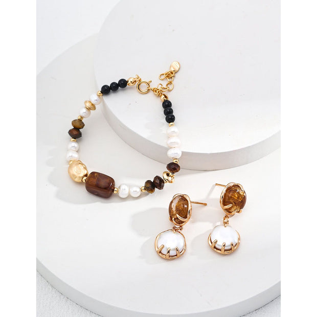 Elegant pearl and gemstone bracelet designed by leading jewelry designers, ideal for jewelry websites and jewelry storage. Featuring a mix of tiger's eye, onyx, and pearls, this vintage-inspired gem jewelry is perfect for mature women hairstyles, earrings piercing, and earrings rings. A must-have for jewelry of the sea lovers and those seeking jewelry with turquoise or engraving. Store in a jewelry case and maintain with jewelry cleaning for timeless appeal. Shop at jewelry brands offering body jewelry plus