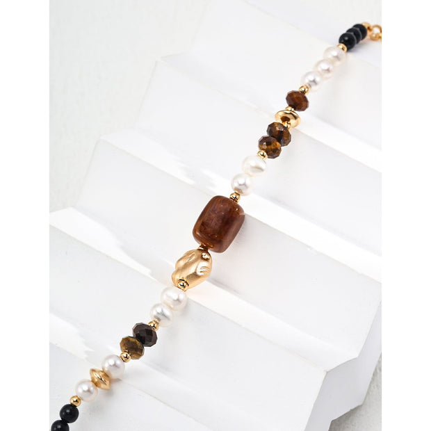 Elegant pearl and gemstone bracelet designed by leading jewelry designers, ideal for jewelry websites and jewelry storage. Featuring a mix of tiger's eye, onyx, and pearls, this vintage-inspired gem jewelry is perfect for mature women hairstyles, earrings piercing, and earrings rings. A must-have for jewelry of the sea lovers and those seeking jewelry with turquoise or engraving. Store in a jewelry case and maintain with jewelry cleaning for timeless appeal. Shop at jewelry brands offering body jewelry plus