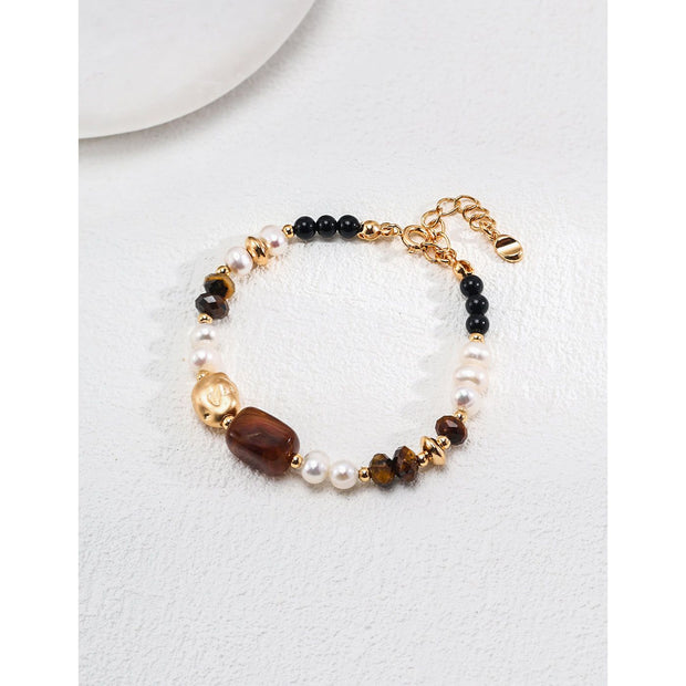 Elegant pearl and gemstone bracelet designed by leading jewelry designers, ideal for jewelry websites and jewelry storage. Featuring a mix of tiger's eye, onyx, and pearls, this vintage-inspired gem jewelry is perfect for mature women hairstyles, earrings piercing, and earrings rings. A must-have for jewelry of the sea lovers and those seeking jewelry with turquoise or engraving. Store in a jewelry case and maintain with jewelry cleaning for timeless appeal. Shop at jewelry brands offering body jewelry plus