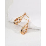 Vintage gold floral drop earrings with pearl accents, perfect for jewelry storage in a jewelry case. Ideal for jewelry designers, vintage jewelry lovers, and jewelry websites. A timeless addition for earrings piercing or body jewelry plus collections, suitable for jewelry brands and mature women hairstyles.